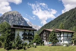 un hôtel avec une montagne en arrière-plan dans l'établissement Sporthotel by Alpenlodge, à Brand