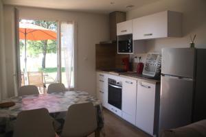 a kitchen with a table and a white refrigerator at L Ostalet Tarn et Garonne in Bressols