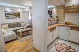 a kitchen and living room with a couch and a table at Lux Centre Apartment in Žabljak