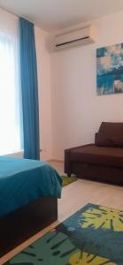een slaapkamer met een bed, een bank en een tapijt bij Apart hotel Sara seaview in Olimp