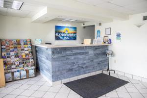 un mostrador en una tienda con un cartel en la pared en Sandcastle Inn, en Tybee Island