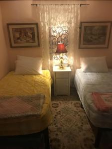 um quarto com 2 camas e uma mesa com um candeeiro em Billie's Backpackers Hostel em Fairbanks