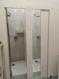 um chuveiro com uma porta de vidro na casa de banho em Evergreen Hostel Krakow em Cracóvia
