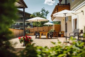 a patio with a table and two umbrellas at Stangl Appartements in Flachau