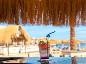 ハルガダにあるMOON - Apartment with swimming pool and BBQ terrace in CENTER CITY HRGのビーチが見えるテーブルに置かれた飲み物