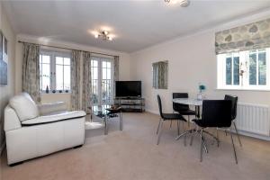 a living room with a white couch and a table at Sunny 1 bed apartment in a quiet central location in Basingstoke