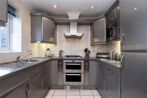 a kitchen with stainless steel appliances and a sink at Sunny 1 bed apartment in a quiet central location in Basingstoke