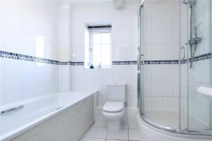 a white bathroom with a toilet and a shower at Sunny 1 bed apartment in a quiet central location in Basingstoke