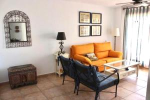 een woonkamer met een oranje bank en een tafel bij APARTAMENTO ZAHARA DE LOS ATUNES in Zahara de los Atunes