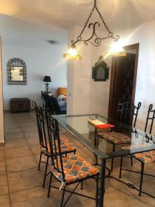 een eetkamer met een glazen tafel en stoelen bij APARTAMENTO ZAHARA DE LOS ATUNES in Zahara de los Atunes
