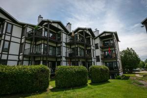 a large building with bushes in front of it at Escapade Pinoteau Tremblant Getaway in Mont-Tremblant