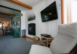 a living room with a couch and a tv on the wall at Escapade Pinoteau Tremblant Getaway in Mont-Tremblant +29 photos
