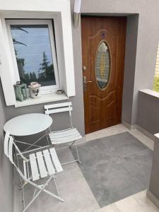 a table and two chairs in front of a door at Apartamenty Wikoli in Międzyzdroje
