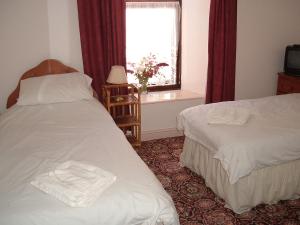 a hotel room with two beds and a window at Morawel in Fishguard