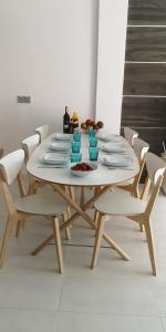Villa La Zenia 25 في بلايا فلامنكا: طاولة مع كراسي بيضاء وطاولة بيضاء مع صحون