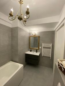 a bathroom with a tub and a sink and a mirror at Seafront Mamaia - Casa Del Mar Residence in Mamaia +50 photos