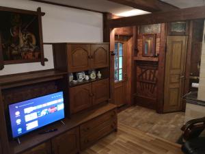 una sala de estar con TV y armarios de madera. en Drewniany domek, en Wielopole Skrzyńskie