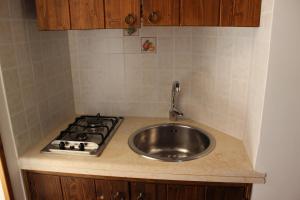 a kitchen counter with a sink and a stove at Masseria Valente in Ostuni