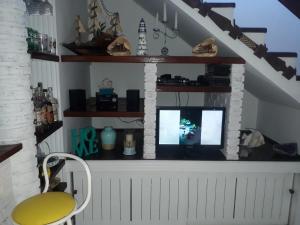 a living room with a fireplace and a yellow chair at CONDOMÍNIO ILHAS DO JUQUEHY in Juquei