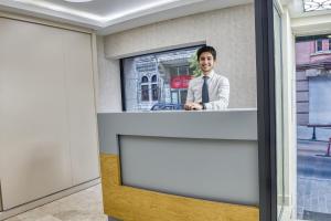 Una foto de un hombre parado en un mostrador en una habitación en Florina Hotel, en Estambul