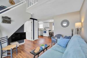 a living room with a blue couch and a kitchen at Odysea in Hampton