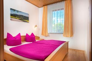 een slaapkamer met een groot bed met roze lakens en een raam bij Ferienhaus "Zur Alten Schule" in Mittelndorf