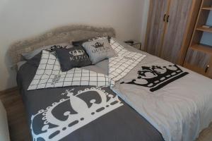a bed with black and white sheets and pillows at Elegant Apartman in Siófok