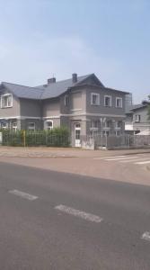 a large house with a fence in front of a street at Apartamenty Wikoli in Międzyzdroje