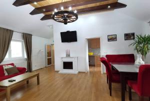 a living room with a dining table and red chairs at Apartament 2 camere - Casa Divertis in Buzau