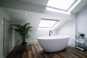 baño con bañera blanca grande y tragaluz en Period Retreat for 6, explore the Lake District, en Lancaster
