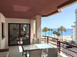 balkon ze stołem i krzesłami oraz plażą w obiekcie Cabeho Beach Homes w mieście Calpe