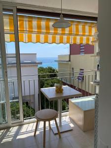 balcón con mesa y vistas al océano en Residence Villa Ombrosa en Spotorno