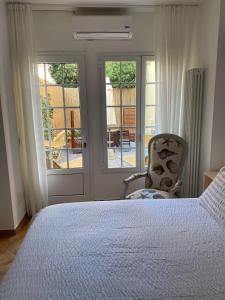 1 dormitorio con 1 cama, 1 silla y puertas correderas de cristal en Residence Villa Ombrosa en Spotorno