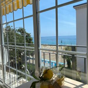 um quarto com uma grande janela com vista para a praia em Residence Villa Ombrosa em Spotorno