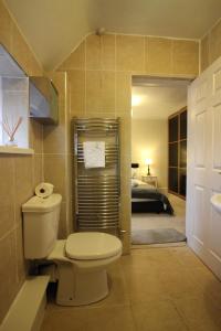 a bathroom with a toilet and a bedroom at Hygge Somerset in Street