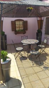 a patio with a table and chairs and a wall at Casa vacanze in Casarano +5 photos