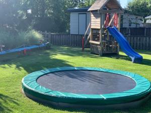 a large trampoline in a yard with a playground at Doelweg 35 Chalet 172 in Goedereede +11 photos