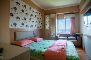 ein Schlafzimmer mit einem Bett, einem Sofa und einem Fenster in der Unterkunft Apartemen Soekarno Hatta by C Management 1 in Malang