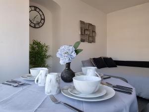 a table with plates and cups and a vase with a flower at Highview House Redcar-Seaview Apartments in Redcar