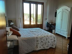 1 dormitorio con cama y ventana grande en Villa Fè -Choose Panoramic View, Jacuzzi, Private Parking, en Montepulciano