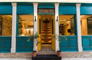 a blue building with a yellow door and stairs at Libretto Suites in Lefkada Town