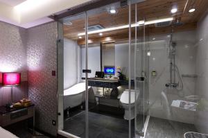 uma casa de banho com um chuveiro e um lavatório. em Beauty Hotels Taipei - Hotel Bfun em Taipei