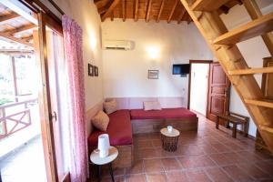 a living room with a red couch in a room at Katikies Stamatias Studios & Maisonettes in Agnontas