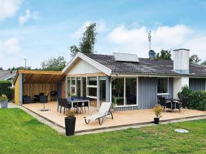 a house with a deck with a table and chairs at 6 person holiday home in Sydals in Neder Lysabild