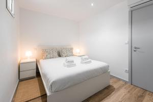 um quarto branco com uma cama branca e uma porta em GuestReady - Palacio Garden 13 no Porto