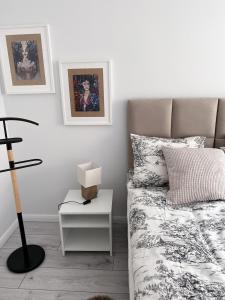 a bedroom with a bed and a table with a lamp at Kosmo Apartament in Wrocław