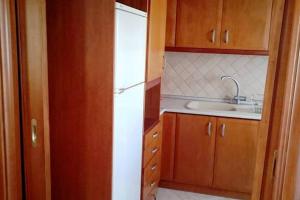 - une cuisine avec des placards en bois et un réfrigérateur blanc dans l'établissement Apartment with two bedrooms in City Centre in Drama Greece, à Dráma