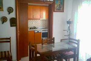 une cuisine avec une table à manger et une cuisine avec des armoires orange dans l'établissement Apartment with two bedrooms in City Centre in Drama Greece, à Dráma