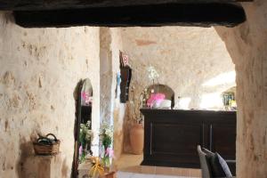 a room with a stone wall with a table and a counter at Masseria Valente in Ostuni