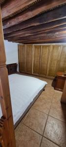 a bed in a room with wooden walls and ceilings at Traditional House in Skiros